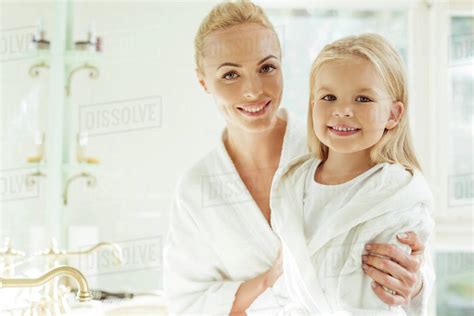 Beautiful Happy Blonde Mother And Daughter In Bathrobes Smiling At