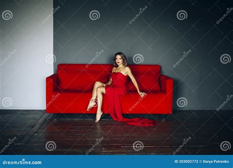 Alluring Woman Sitting On Red Sofa Stock Photo Image Of Attractive