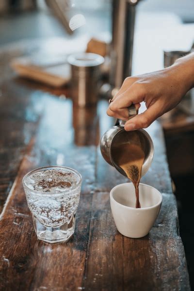 Closeup Of Hand Pouring Coffee Into Cup Free Stock Photos In  Format
