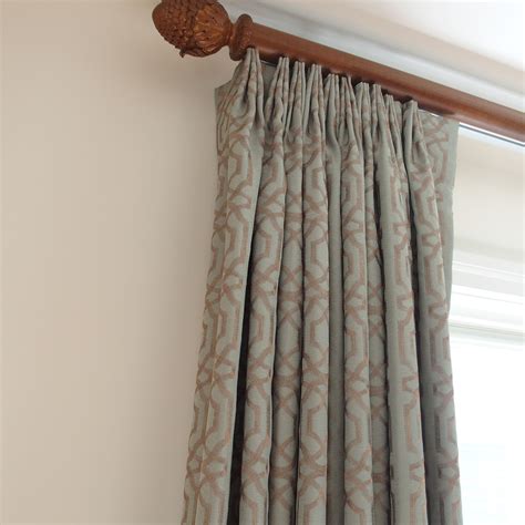 Aqua Embroidered Draperies Installed On Decorative Wood Traverse Rods