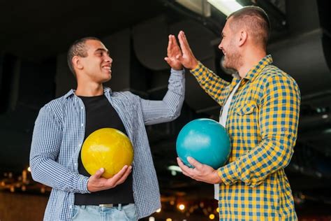 Free Photo Handsome Men Holding Colorful Bowling Balls