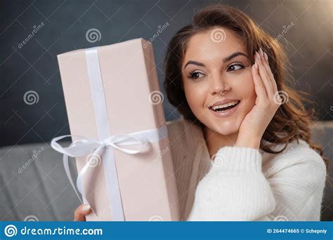 Portrait Of The Surprised Woman Posing With Present Boxes While Sitting At The Sofa Stock Image