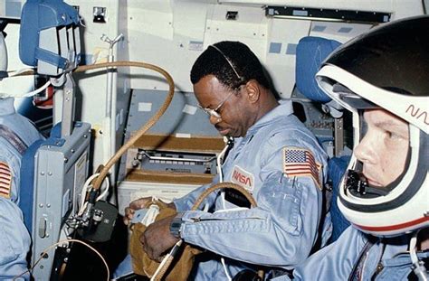 Two Men In Space Suits Working On Equipment