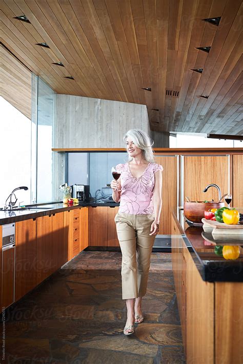mature woman with grey hair walking in luxury kitchen by trinette reed kitchen mature
