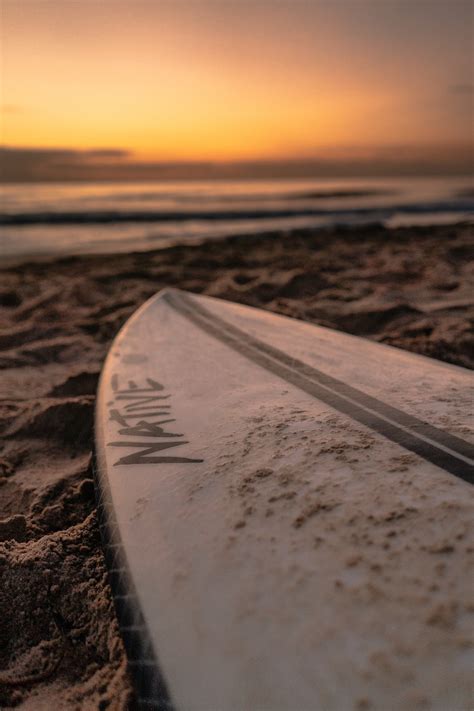 White Surfboard On Brown Sand During Sunset Photo Free Australia