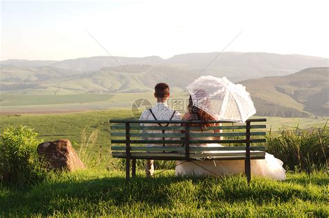 非洲新娘和新郎坐在风景优美的长凳上男人夫妻长椅花园教会新婚套装幸福女孩女性高清图片下载 正版图片322131483 摄图网