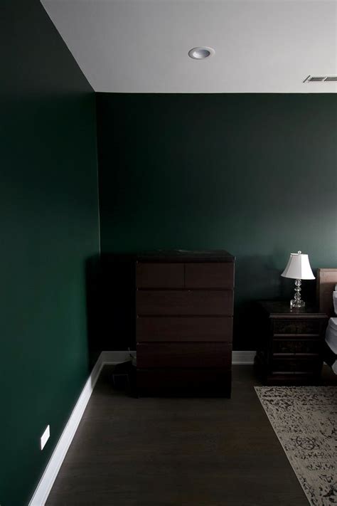A Bedroom With Green Walls And A White Bed In The Middle Along With
