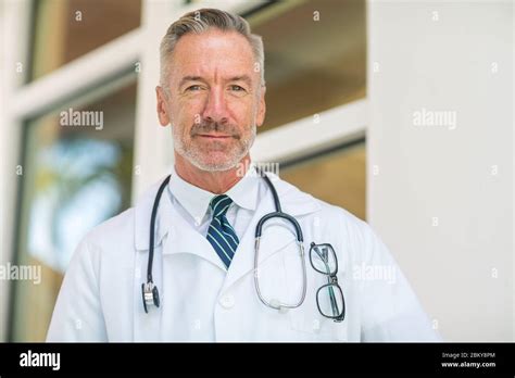 Portrait Of A Mature Handsome Doctor At A Medical Office Stock Photo