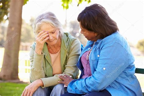 Woman Comforting Unhappy Senior Friend Outdoors — Stock Photo