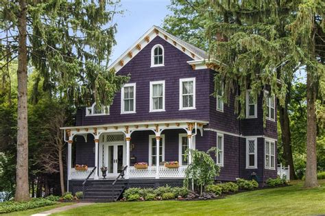 The red color of the brick is echoed in the paint color for the window sashes and gable vent. Purple Victorian Home - Purple Exterior Paint Colors