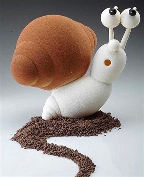 A Snail With Two Eyes Sitting On Top Of Some Brown Dirt Next To A Piece