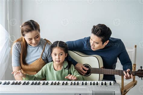 Feliz Pequeña Hija Asiática Tocando El Piano Con Madre Y Padre Tocando