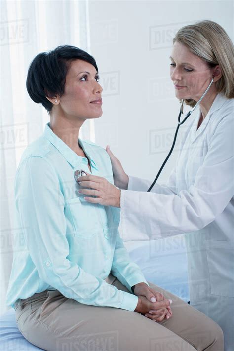 Female Doctor Examining Patient With Stethoscope Stock Photo