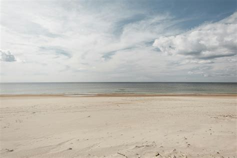 Beach Against Sea Under Cloudy Sky In Daytime · Free Stock Photo