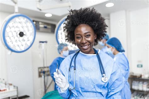 Portrait Of Smiling African American Female Surgeon In Surgical Uniform