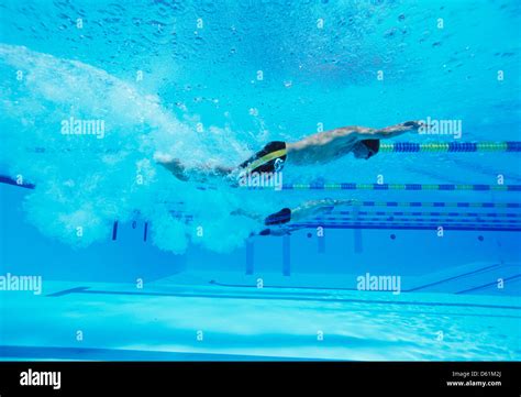 Underwater Shot Of Three Male Thletes Racing In Swimming Pool Stock