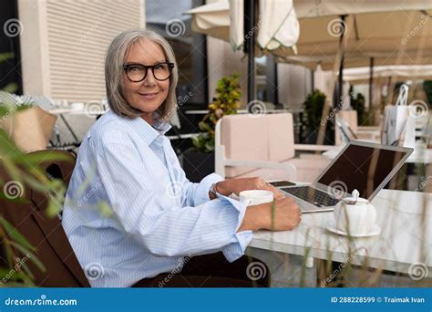 slender well groomed pretty gray haired business woman pensioner spends her lunch break sitting
