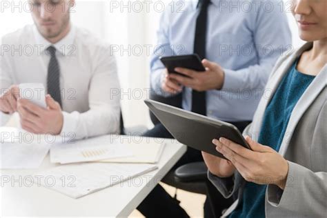 Business People Using Digital Tablets And Cell Phone In Office