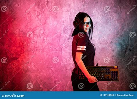 Portrait Of The Beautiful Young Pro Gamer Girl Standing With A Gaming Keyboard And Headset And