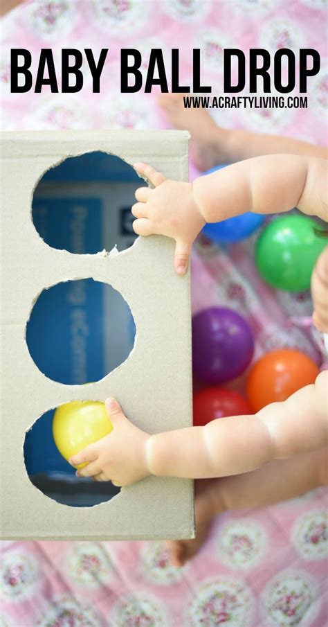 A Baby Is Playing With Some Balls In A Cardboard Box That Says Baby