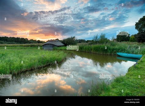 Stunning Sunset Over A Boat And Thatched Boat House In Reeds On The