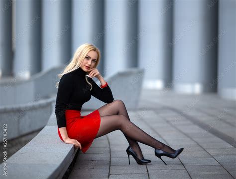 Beautiful Blonde Girl In Red Skirt With Perfect Legs In Pantyhose And Shoes With High Heels