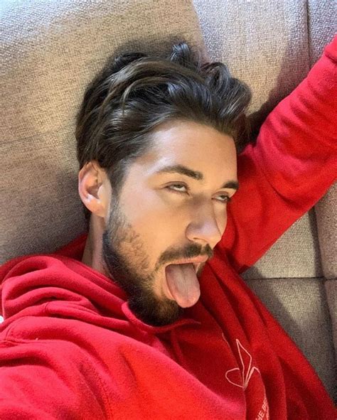 A Man Laying On Top Of A Couch With His Mouth Open And Tongue Hanging Out