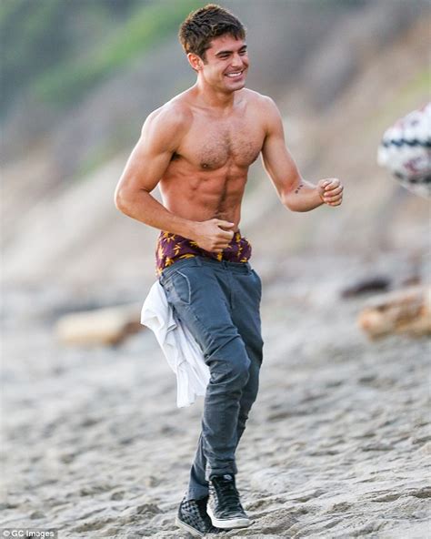 zac efron displays his toned physique as he goes shirtless before putting top back on to film