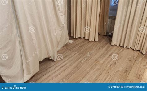 The Floor Has Laminate Boards With A Wooden Texture And Curtains For