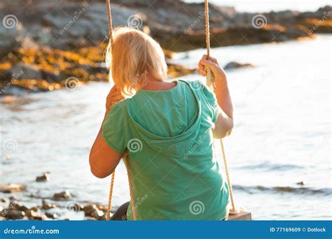 Reife Frau Die Auf Schwingen Am Strand Stillsteht Stockbild Bild Von Ozean Schwingen 77169609