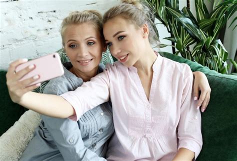 Premium Photo Portrait Of Beautiful Mature Mother And Her Daughter Making A Selfie Using Smart