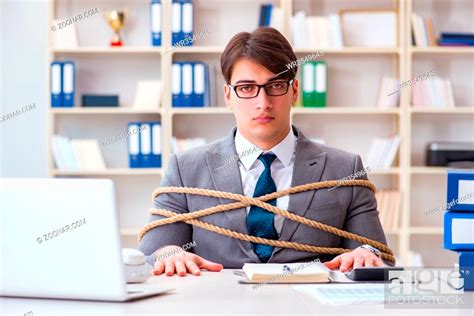 Businessman Tied Up With Rope In Office Stock Photo Picture And