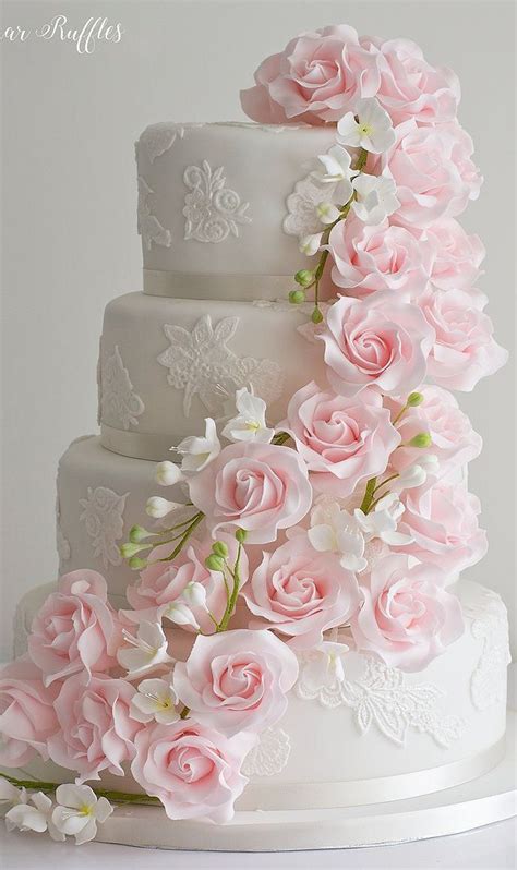 A White Wedding Cake With Pink Flowers On Top