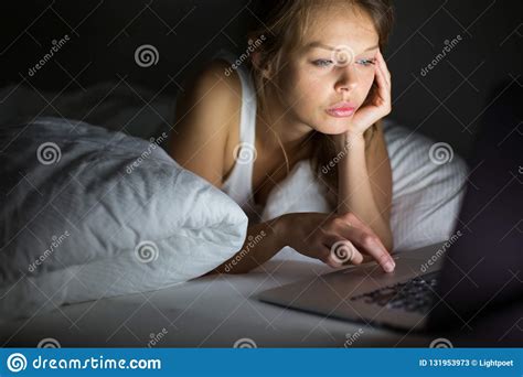 Pretty Young Woman Using Her Laptop Computer In Bed Stock Image