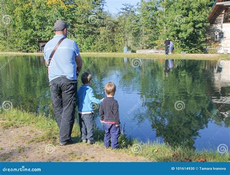 A Man And Two Children Fishing Father And Two Sons Fishing Trout At A