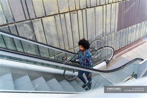 Stylish Man Carrying Bicycle On Escalator — Spain Copy Space Stock
