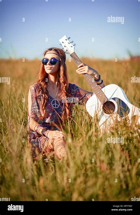 Portrait Of A Lovely Young Hippie Girl With Guitar Shot In The Field