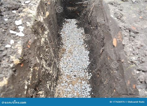 Digging A Deep Trench And Filling It With Stone Gravel To Construct A