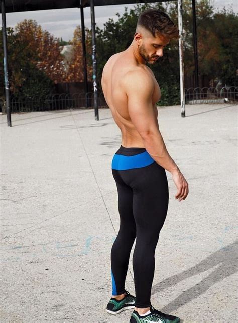 A Man In Black And Blue Tights Standing On A Skateboard With His Back