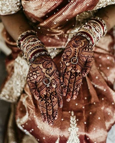 A Woman With Henna On Her Hands And Arm Covered In Intricately Designed