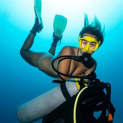 A Woman In Yellow Scuba Gear Is Posing For The Camera With Her Snorkels
