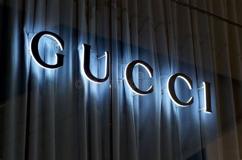 Segno Gucci Illuminato Con Sfondo Di Cortina Blu Fotografia Editoriale