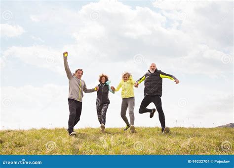 Group Of Senior Runners Outdoors Resting Holding Hands Stock Photo