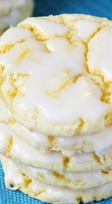 A Stack Of White Frosted Cookies Sitting On Top Of A Blue Cloth