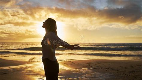 Silhouette Of A Woman On The Beach At Sunset Outside Profile Of Female Stretching Her Arms