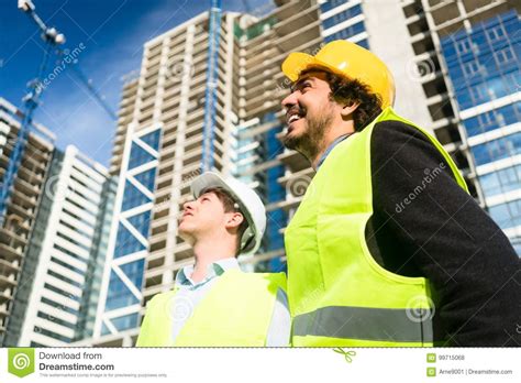 Architects On Large Construction Site Giving Instructions Stock Photo