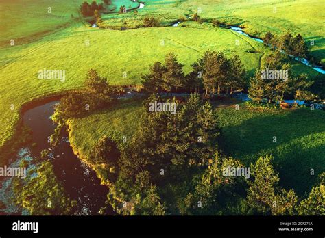 Aerial View Of Mountain Creek Winding Through Beautiful Grassy