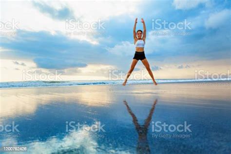 Young Woman Doing Jumping Jack Or Star Jumps Exercise Stock Photo