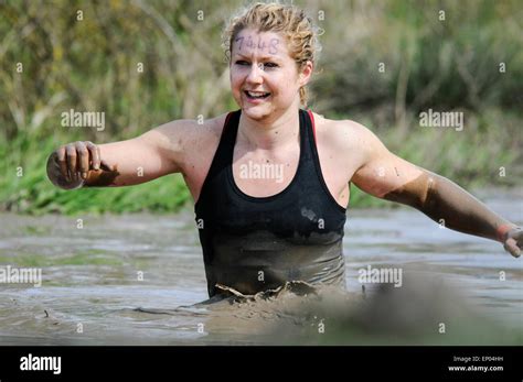 Mud Covered Young Woman Competitor Waist Deep In Mud Lake Obstacle