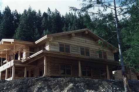 This Dovetail Log Home Appears To Perch Atop Its Stony Foundation In